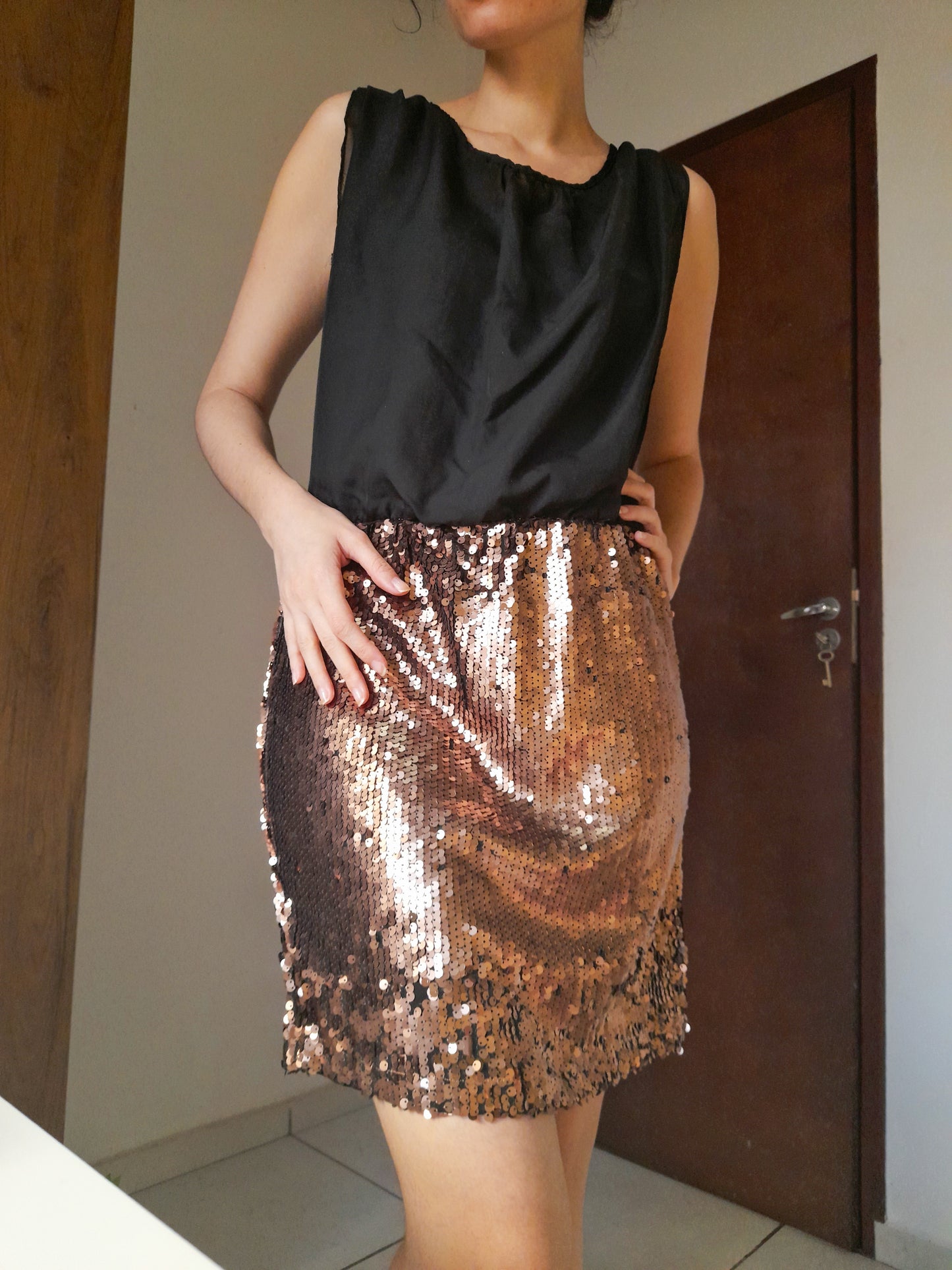 Vestido curto preto com saia de paetês dourados